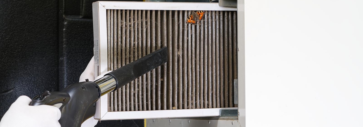 Dirty Air filter being cleaned or replaced for home central air conditioning system.