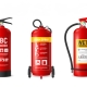 An infographic displaying five different types of fire extinguishers: Carbon Dioxide, ABC Powder, Foam Spray, Wet Chemical, and Water Spray. Each extinguisher is labeled with its type and shows a distinct design and color coding. The title reads 'EXTINGUISHER TYPE CYLINDER CONTAINS,' indicating the contents and uses of each extinguisher type. The image serves as a visual guide for identifying the appropriate extinguisher for various fire situations.